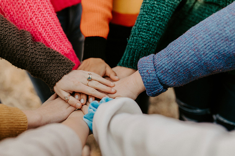 People put their hands together in a show of social support.